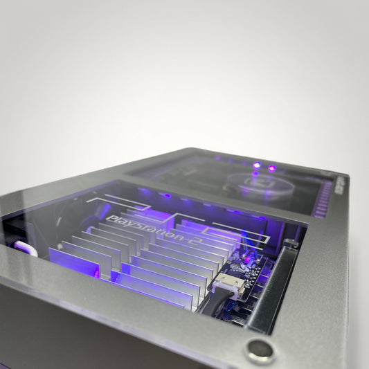 StudioFR customized purple and grey PlayStation 2 Fat console with internal RGB lighting and clear top.