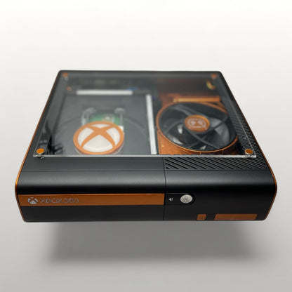StudioFR custom black and copper Xbox 360E console with clear top window showing internal components and RGB lighting.