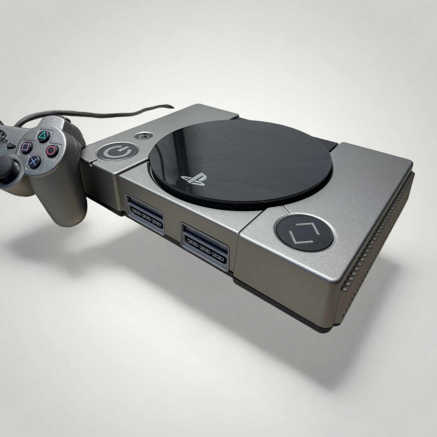 StudioFR custom black and grey PlayStation 1 console with matching controller and engraved buttons. Features RGB lighting.