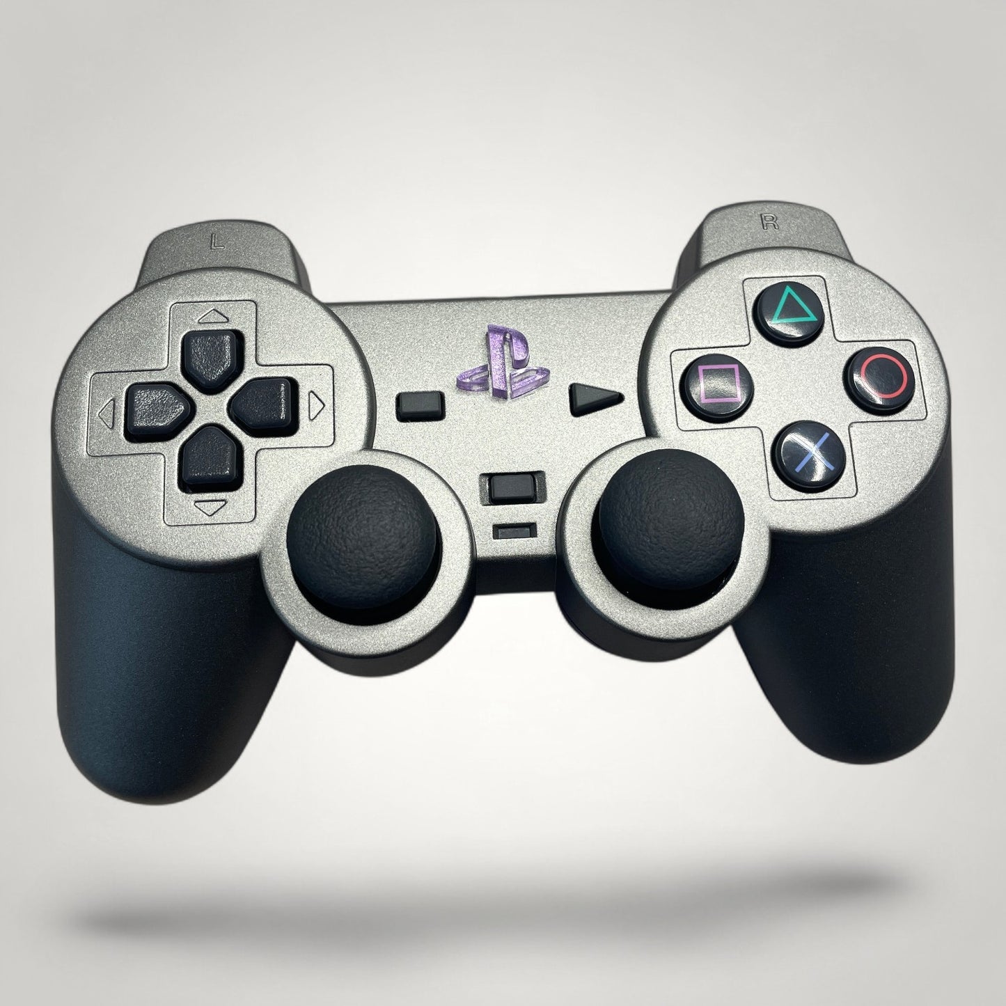 StudioFR custom grey and purple PS2 Fat controller with engraved PlayStation logo and RGB lighting.