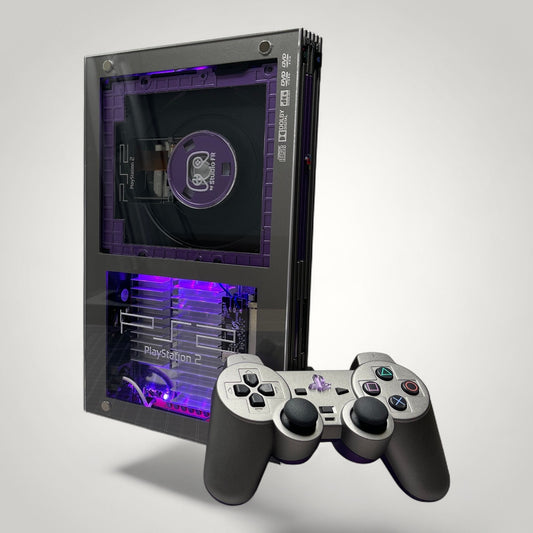 StudioFR custom purple and grey PlayStation 2 Fat console with RGB lighting and matching controller.