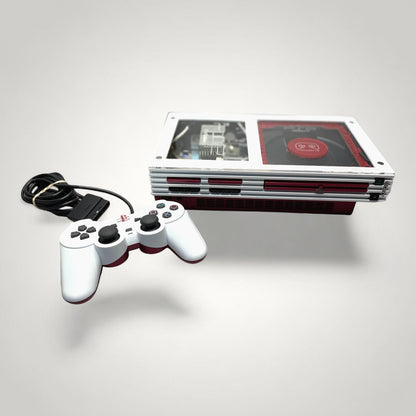 StudioFR custom red and white PlayStation 2 Fat console with a matching white controller. Features clear top with visible internals and RGB lighting.