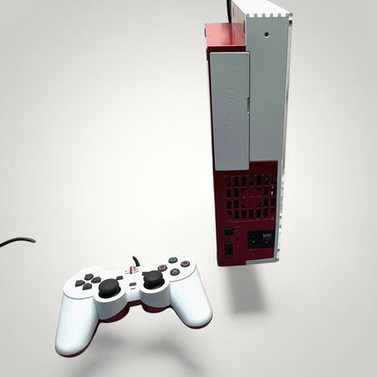 StudioFR customized red and white PlayStation 2 Fat console with matching controller. Features RGB lighting and custom engraved logos.