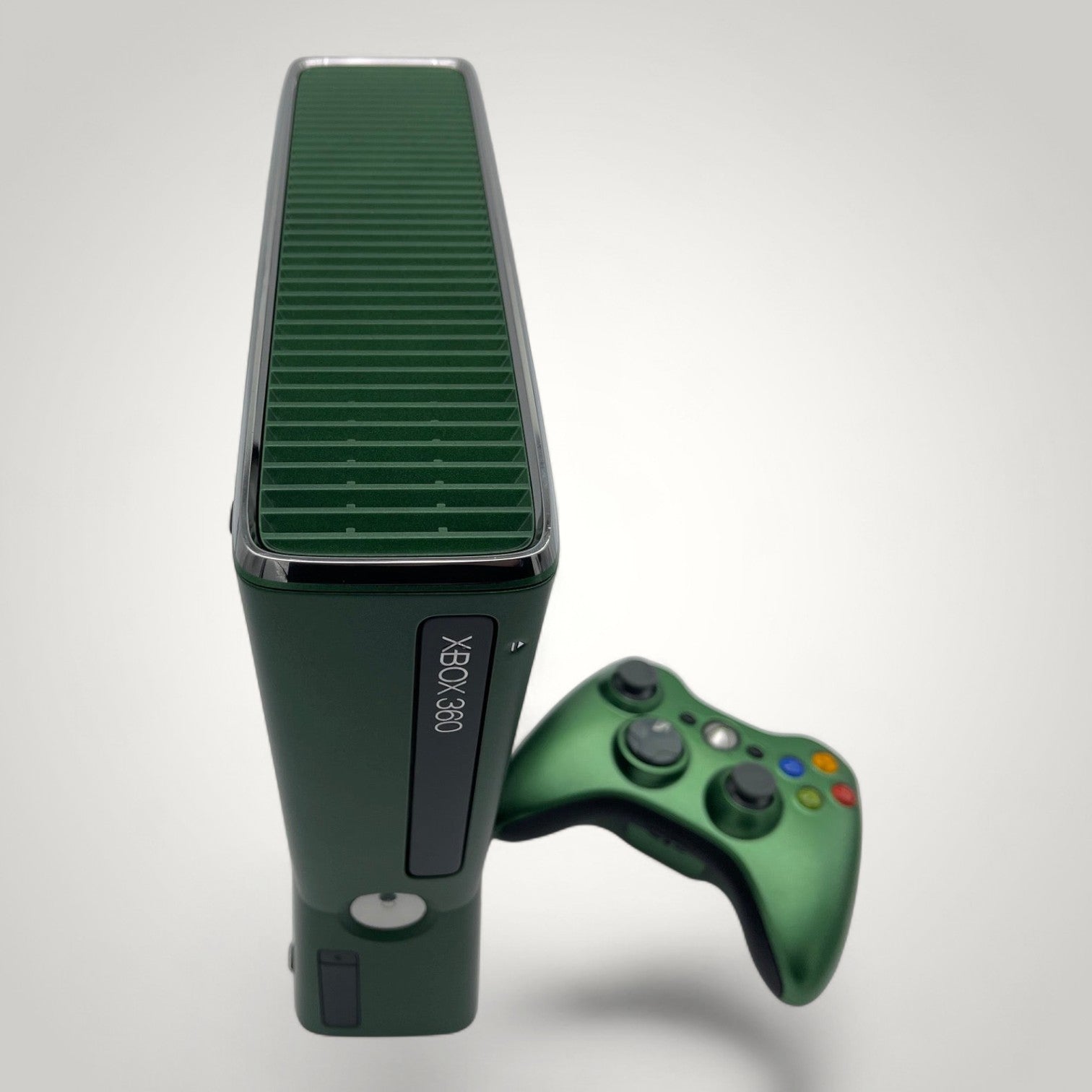 StudioFR custom black and green Xbox 360 Slim console with matching controller. Features a window mod with engraved logo and RGB lighting.