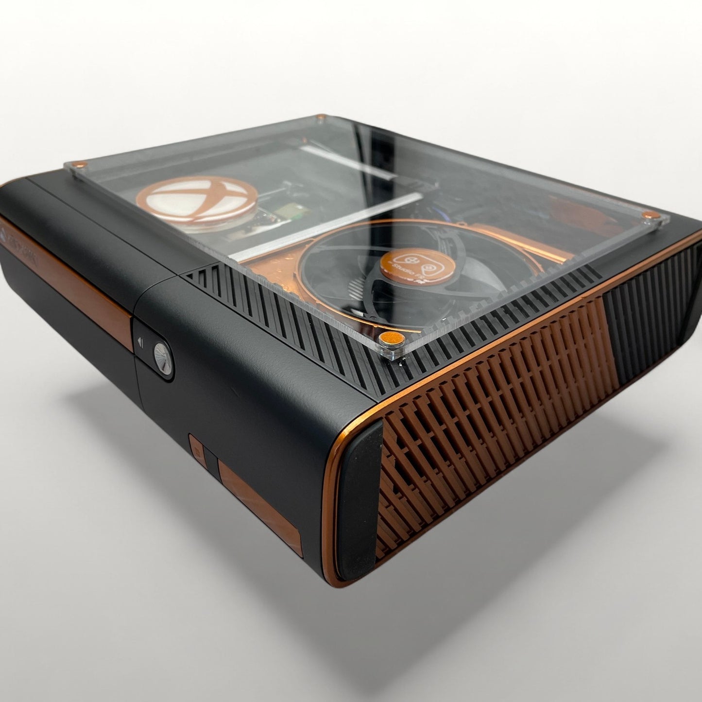 StudioFR customized black and copper Xbox 360E console with clear top showing internal components and RGB lighting.